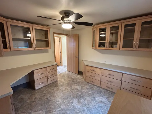a view of an empty room with a ceiling fan and window