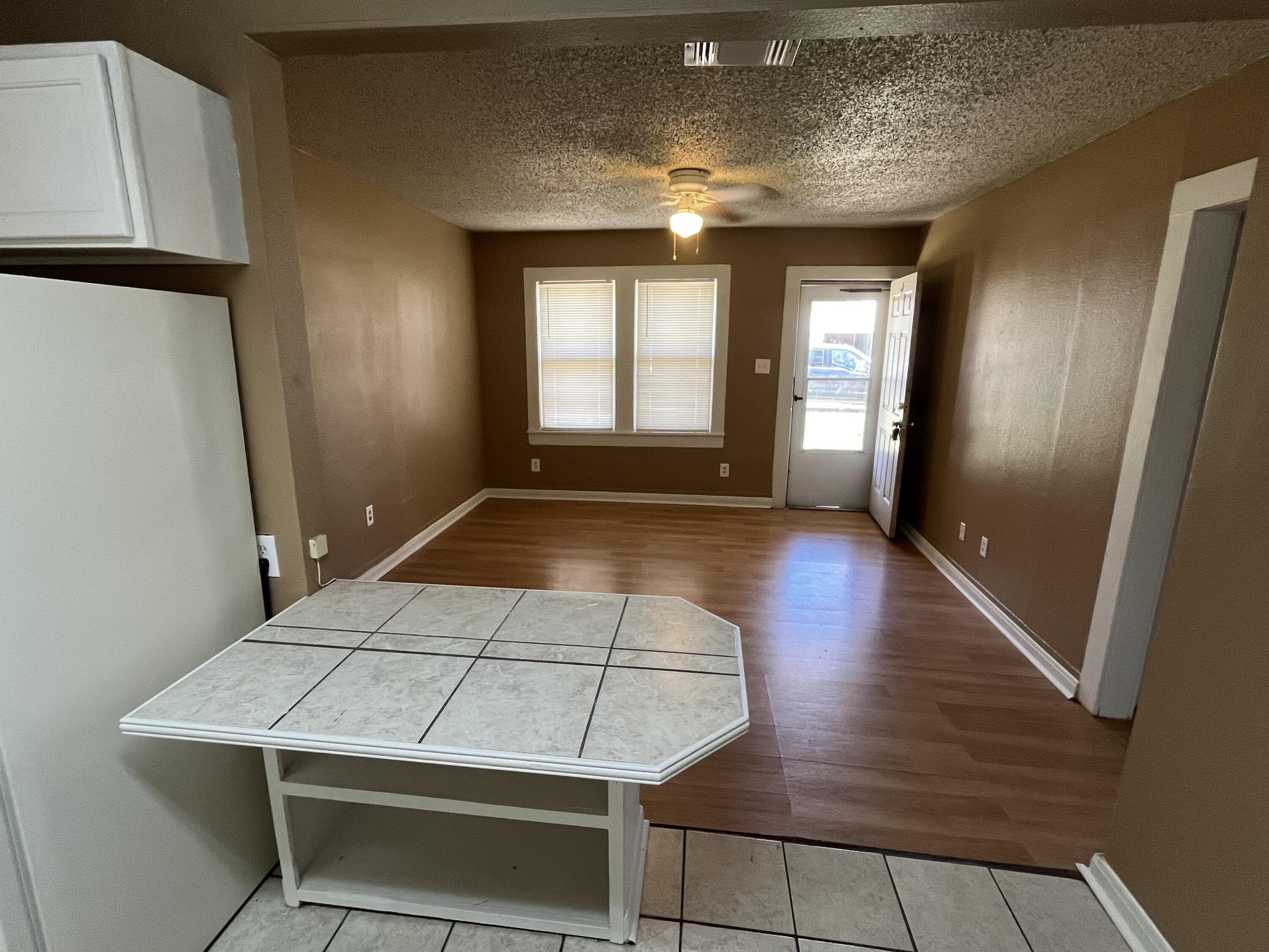 2111 25th Street Lubbock, TX 79411 - Photo 2 of 8 an empty room with wooden floor and windows