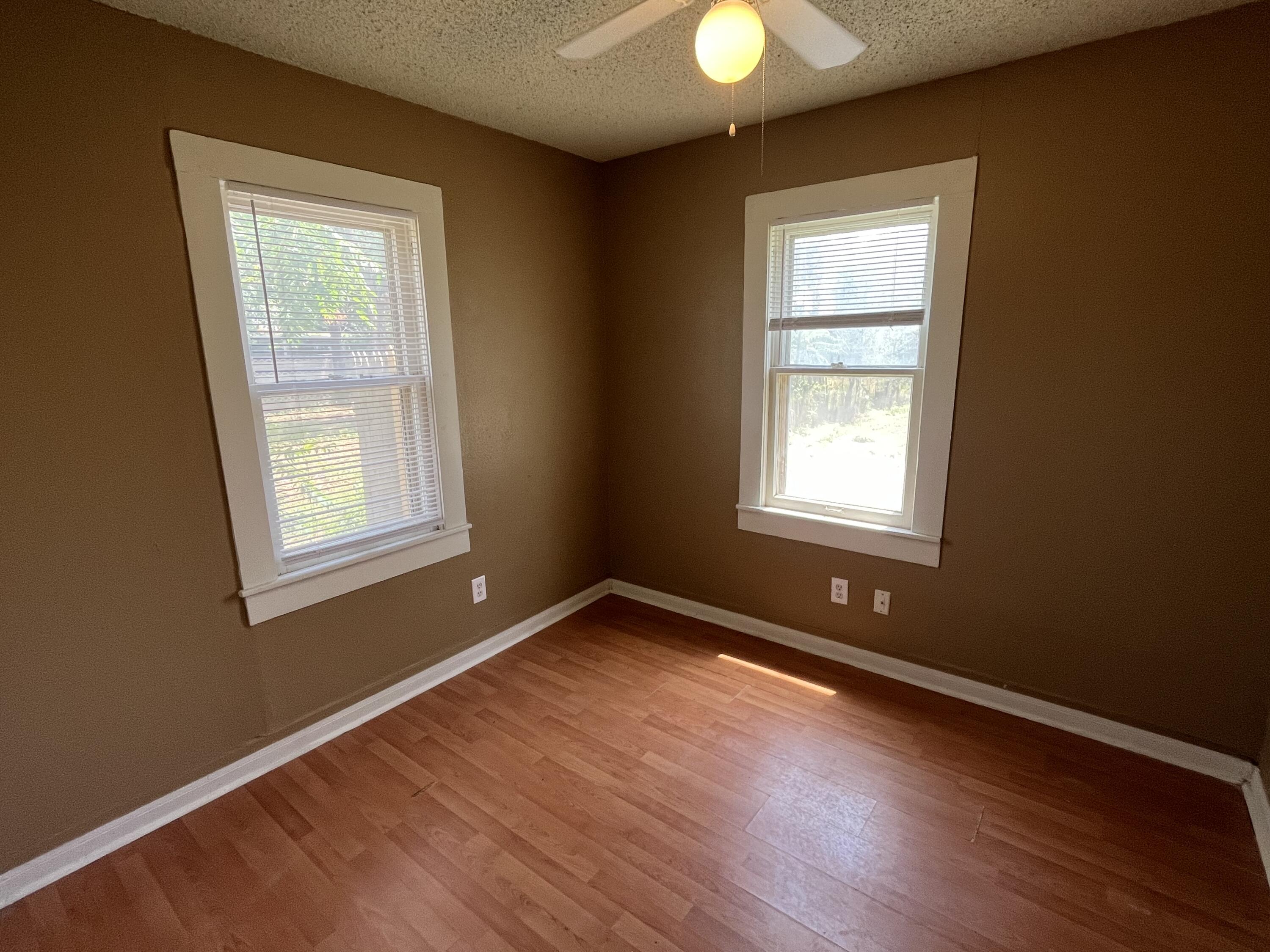 2111 25th Street Lubbock, TX 79411 - Photo 7 of 8 a view of an empty room with wooden floor and a window