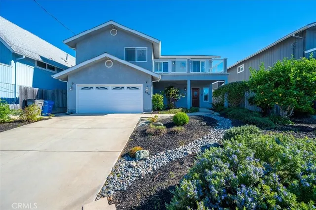 a front view of a house with a yard and potted plants
