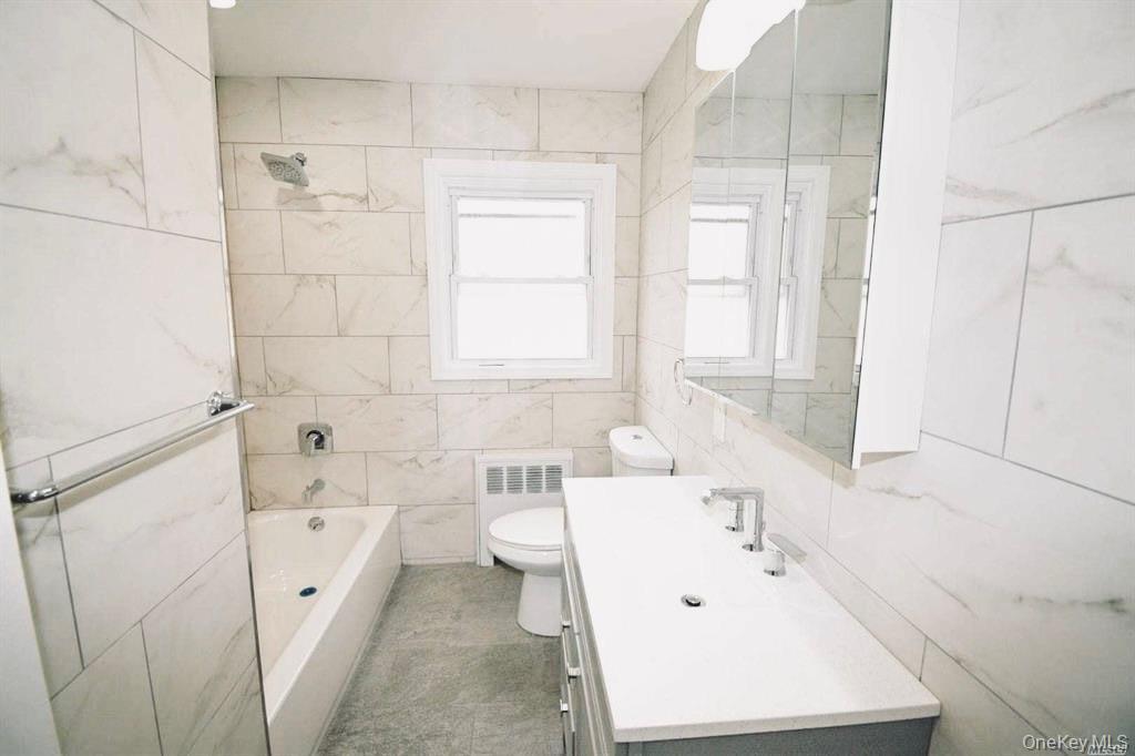 241 Woodbury Road Hicksville, NY 11801 - Photo 9 of 13 a bathroom with a bathtub sink and a toilet