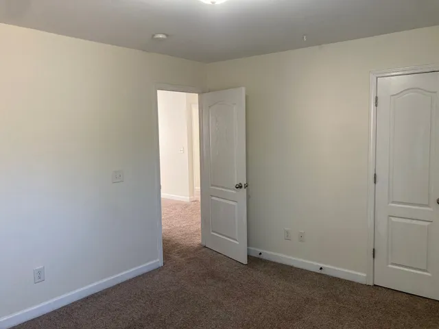 an empty room with a window and a chandelier fan