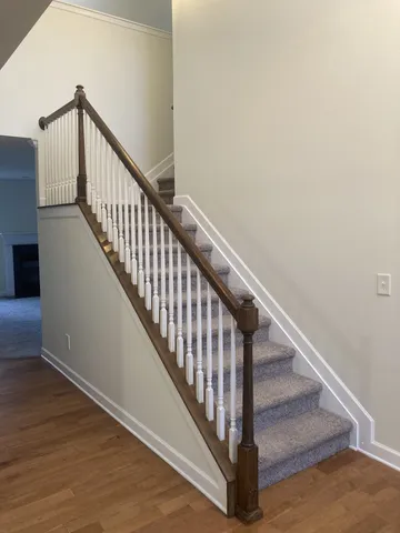 a view of staircase with wooden floor and white walls