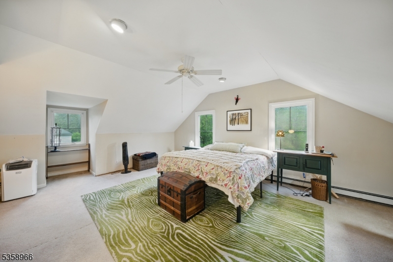 351 Franklin Road Denville, NJ 07834 - Photo 16 of 48 a spacious bedroom with a bed a table and chair