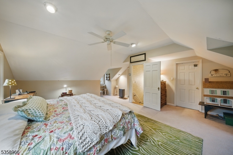 351 Franklin Road Denville, NJ 07834 - Photo 18 of 48 a spacious bedroom with a bed and a book shelf