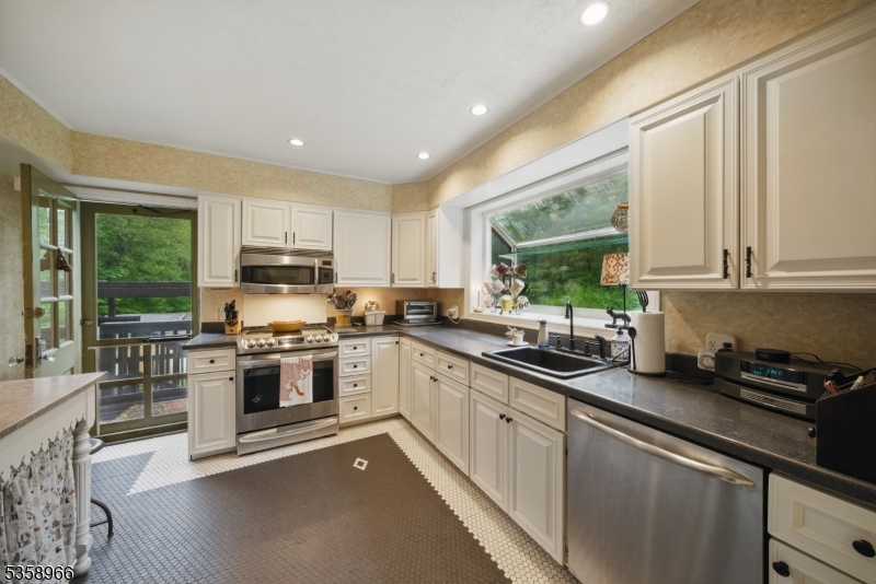 351 Franklin Road Denville, NJ 07834 - Photo 34 of 48 a kitchen with stainless steel appliances granite countertop white cabinets a sink dishwasher a stove and a refrigerator with wooden floor