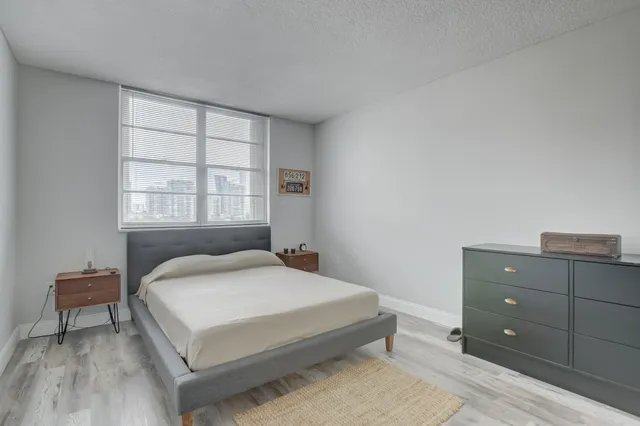 a bedroom with a bed and wooden floor