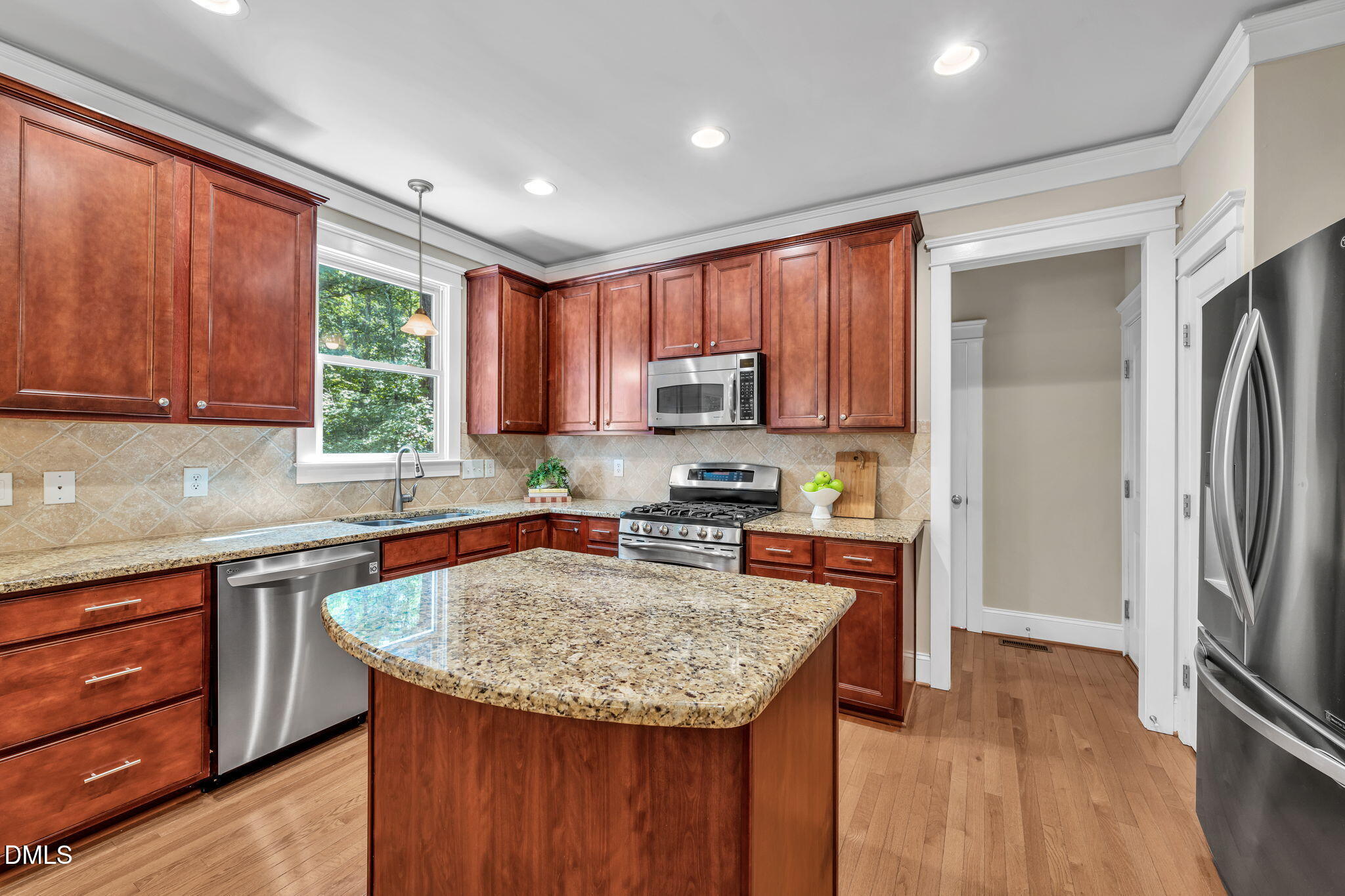 4324 Brighton Ridge Drive Apex, NC 27539 - Photo 12 of 37 a kitchen with stainless steel appliances granite countertop a refrigerator a sink dishwasher a stove top oven a large island with wooden floor and cabinets