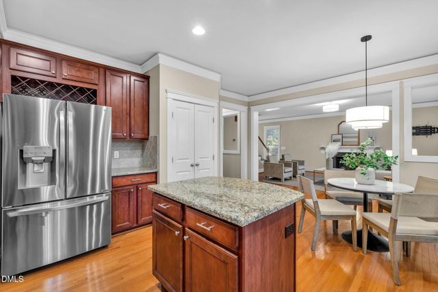 a kitchen with granite countertop a refrigerator and microwave