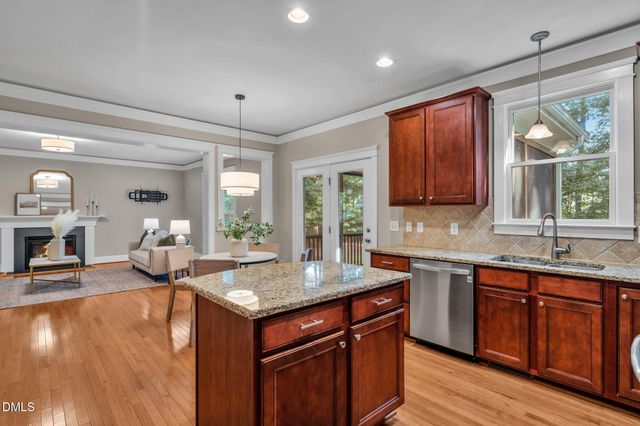 a kitchen with stainless steel appliances granite countertop sink stove and wooden floor