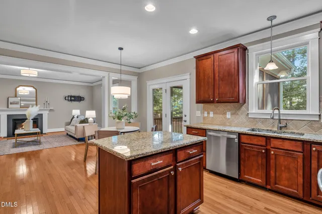 a kitchen with stainless steel appliances granite countertop sink stove and wooden floor