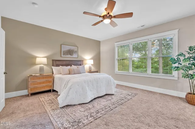 a bedroom with a bed painting on wall and a large window