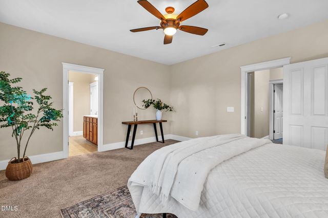 a bedroom that has a bed and a potted plant