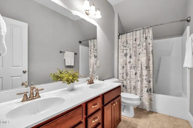 a bathroom with a double vanity sink toilet and shower