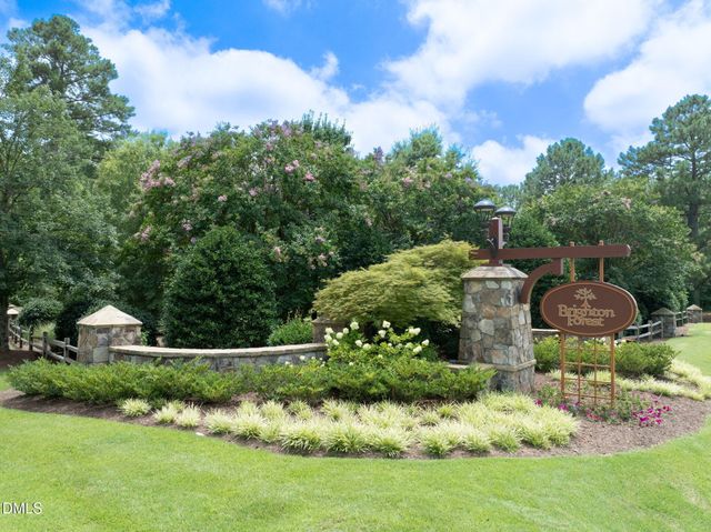 a view of a house with a yard and potted plants