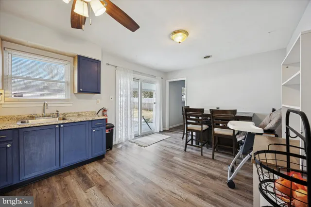 a large kitchen with stainless steel appliances granite countertop a table chairs and a wooden cabinets