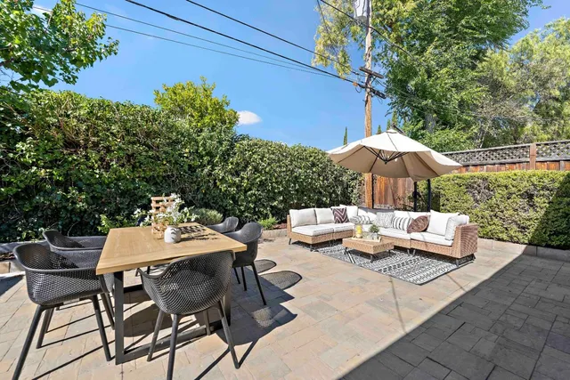 a view of a patio with chairs and table under an umbrella