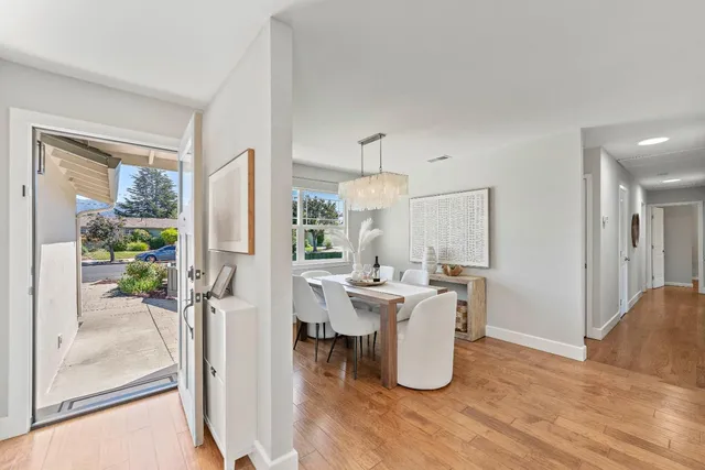 a dining room with furniture and a floor to ceiling window