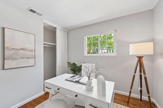 a view of a workspace with furniture and a window