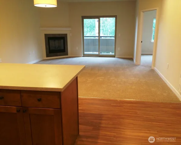 a view of an empty room with a fireplace and a window