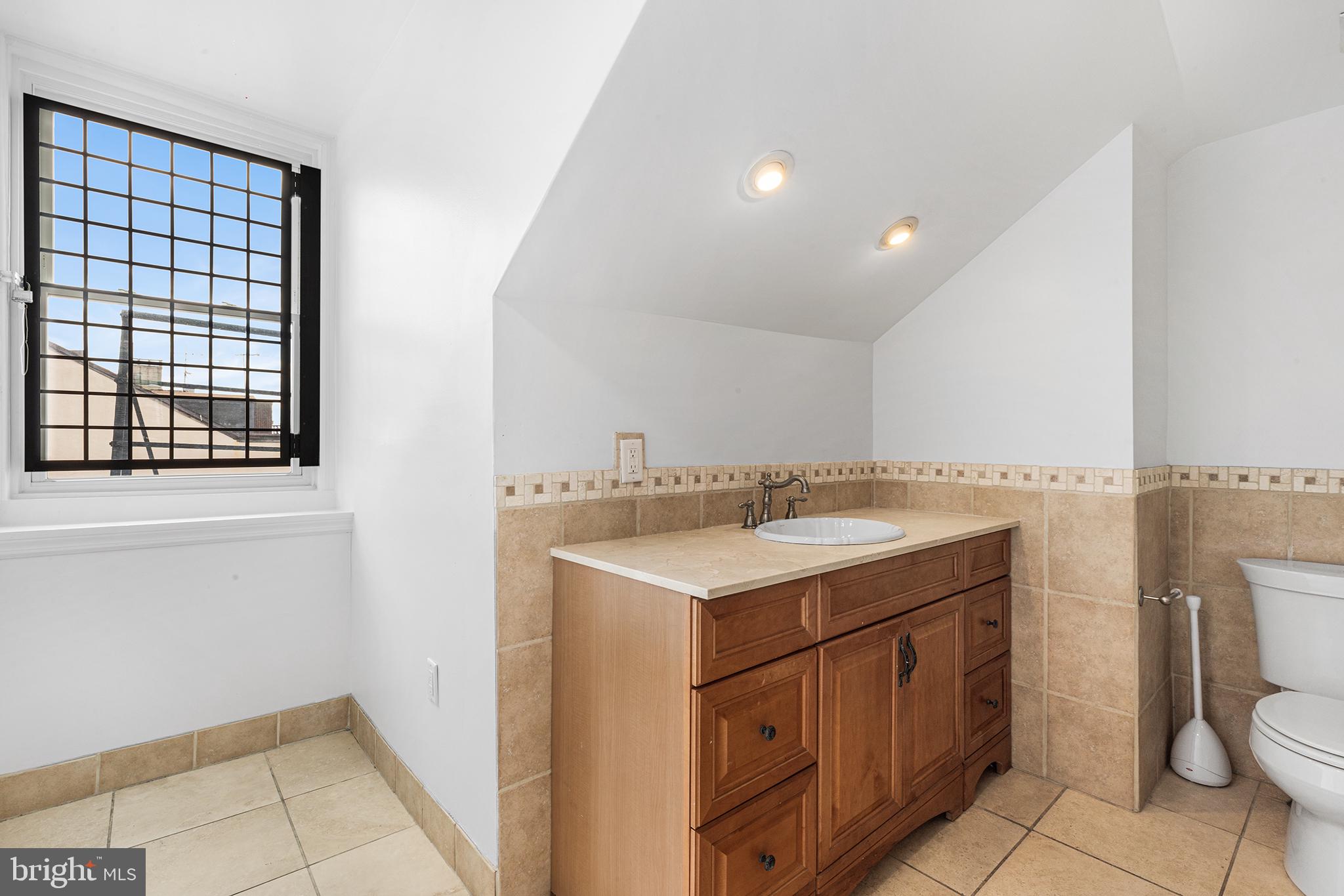 902 Pine Street, Unit 3F Philadelphia, PA 19107 - Photo 15 of 22 a utility room with a sink a toilet and a mirror