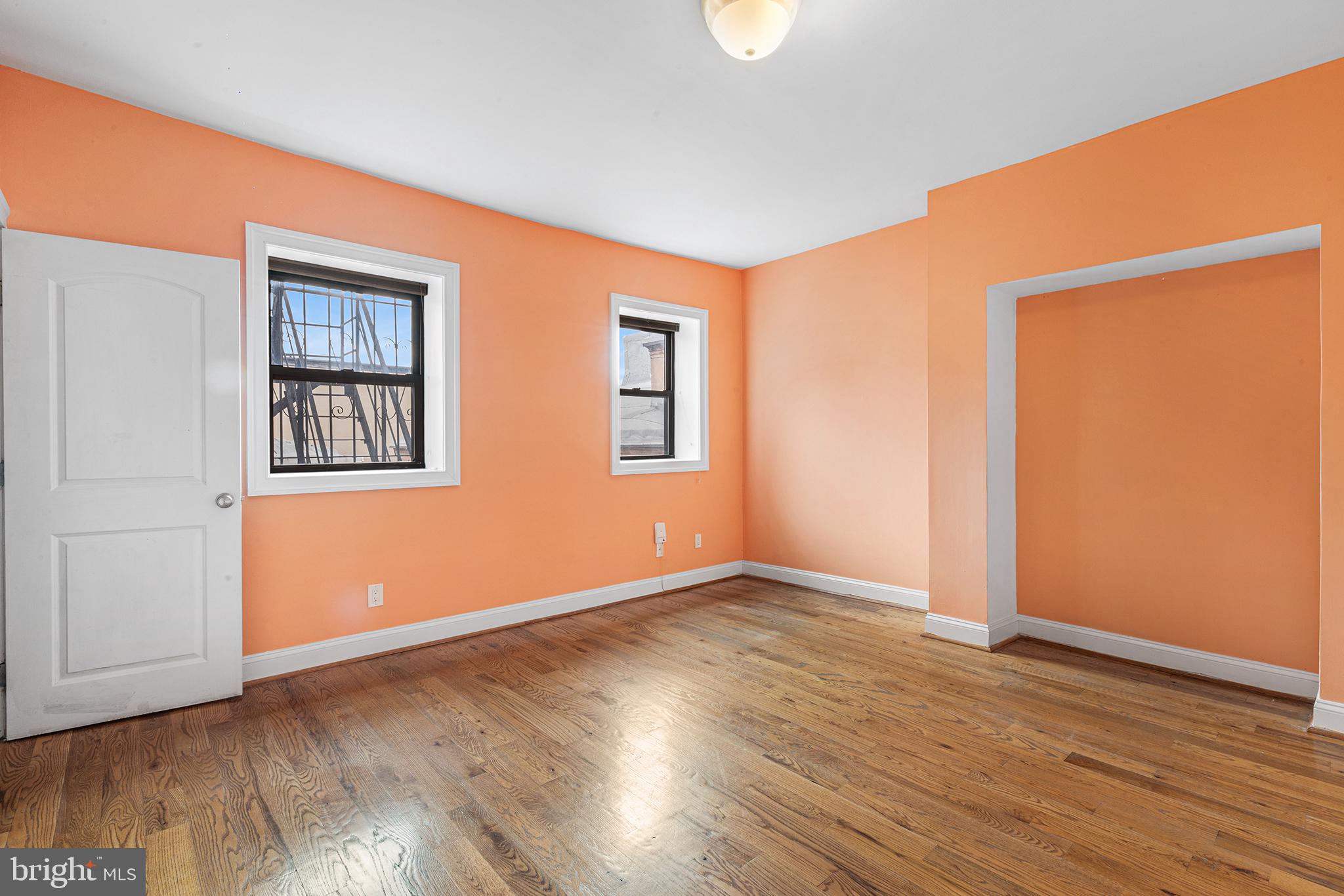 902 Pine Street, Unit 3F Philadelphia, PA 19107 - Photo 20 of 22 an empty room with wooden floor and windows