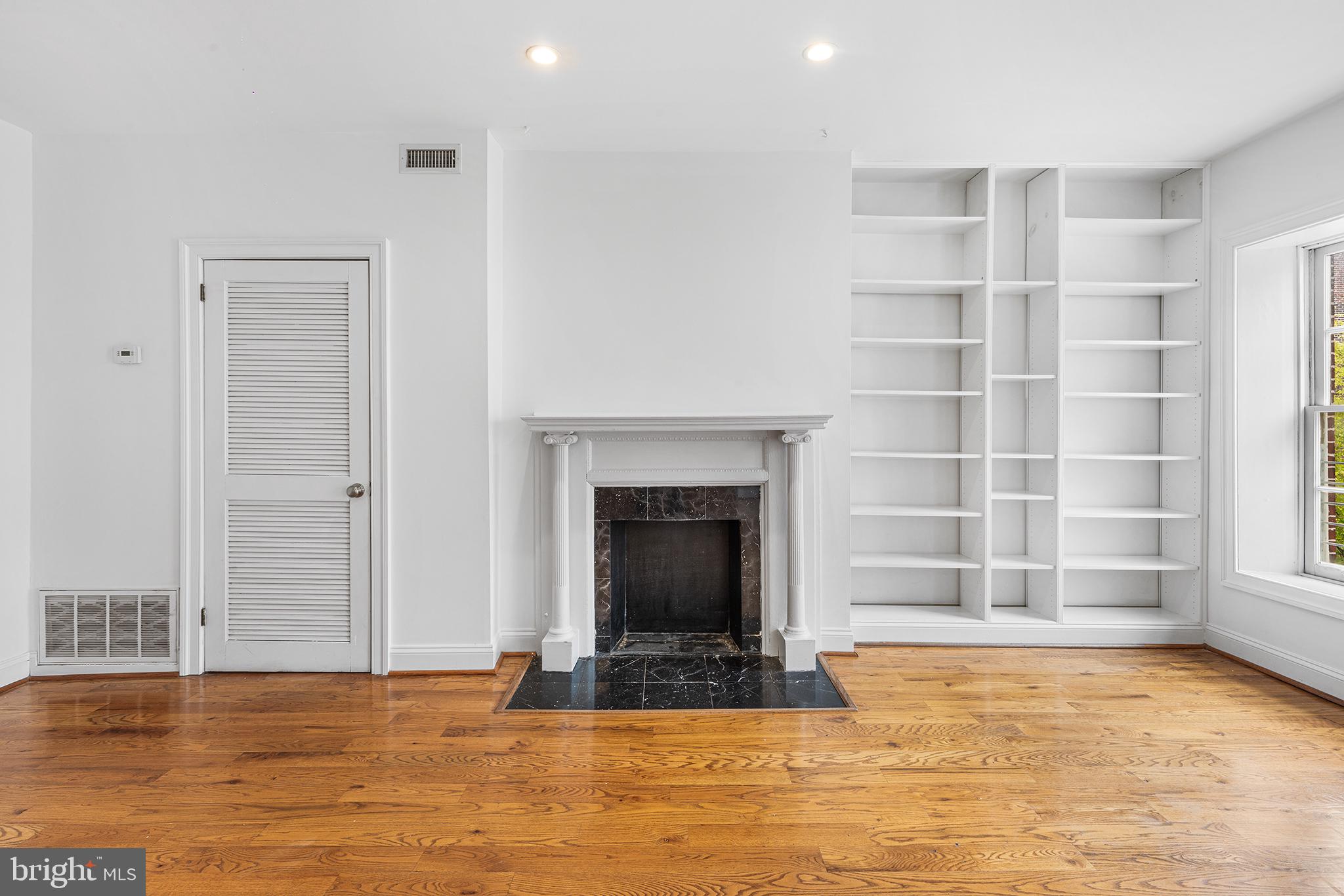 902 Pine Street, Unit 3F Philadelphia, PA 19107 - Photo 3 of 22 a view of an empty room with a fireplace and a window