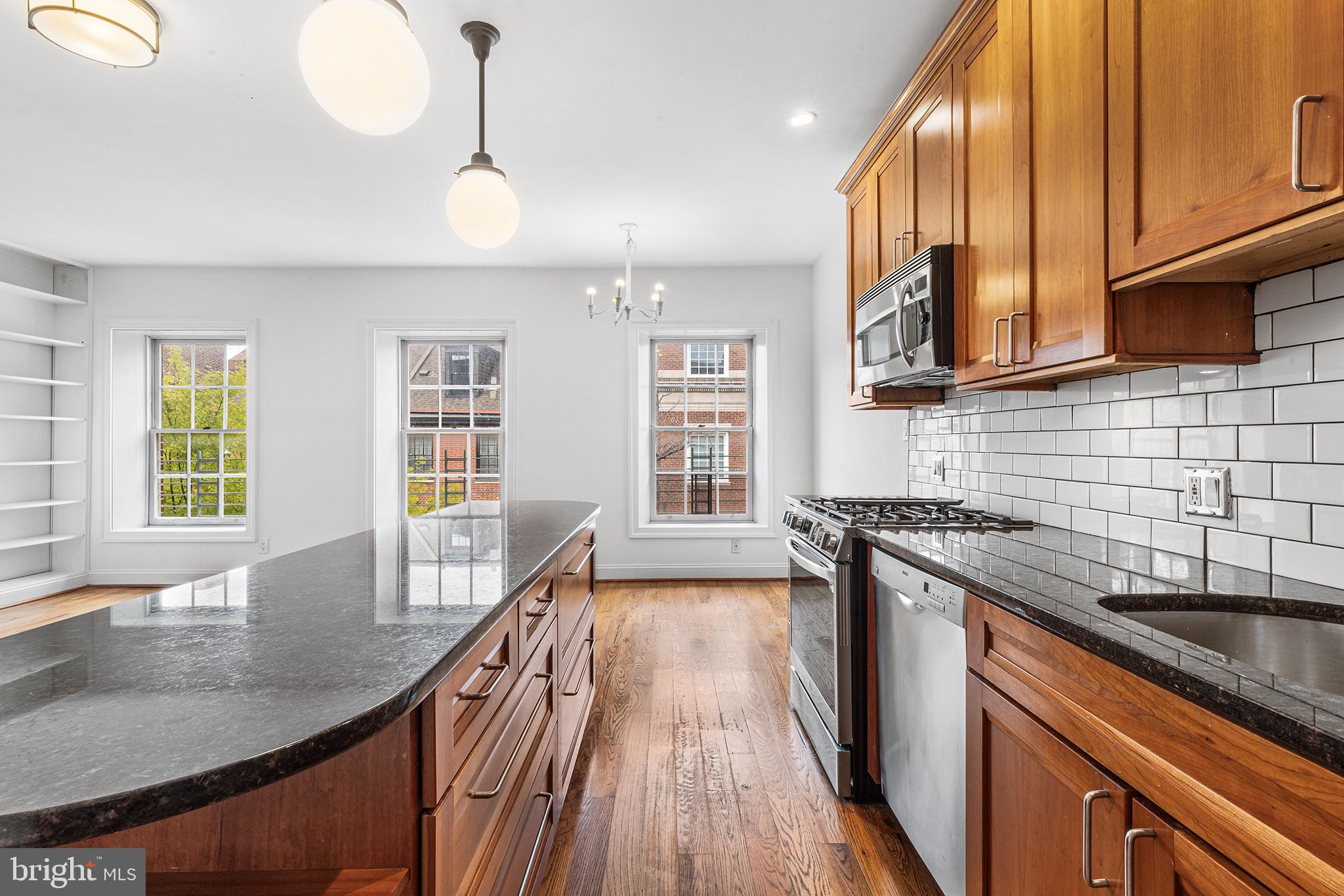 902 Pine Street, Unit 3F Philadelphia, PA 19107 - Photo 6 of 22 a kitchen with stainless steel appliances granite countertop a sink a stove and a wooden floors