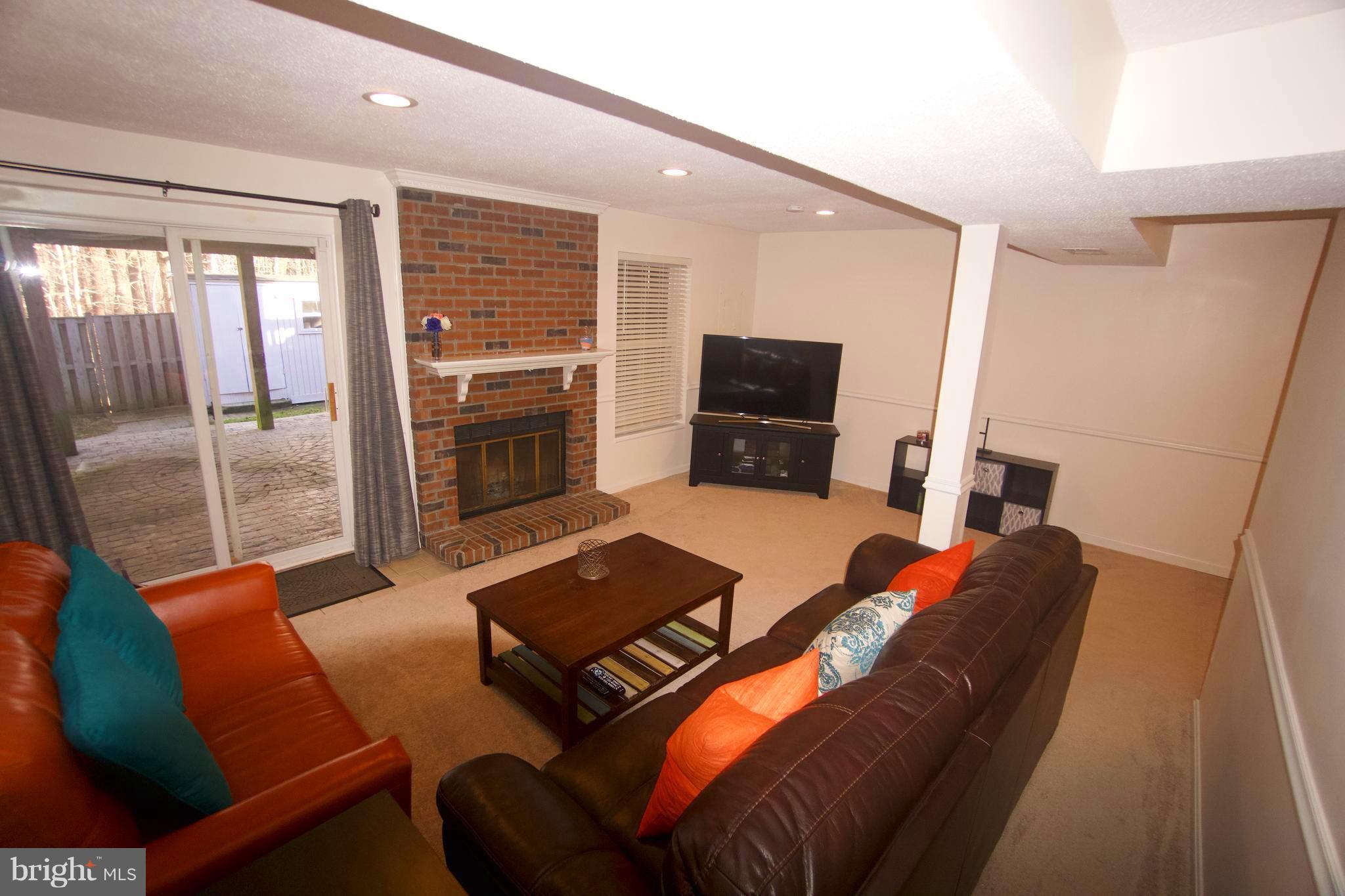 6261 Rathlin Drive Springfield, VA 22152 - Photo 21 of 26 a living room with furniture a flat screen tv and a fireplace