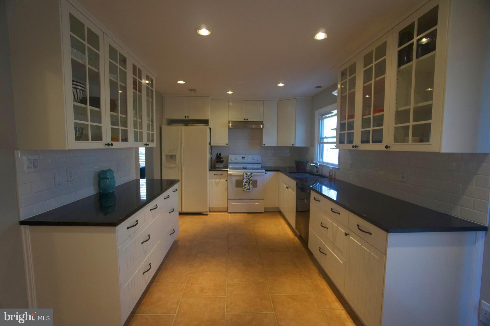 6261 Rathlin Drive Springfield, VA 22152 - Photo 7 of 26 a kitchen with stainless steel appliances granite countertop a refrigerator and a sink