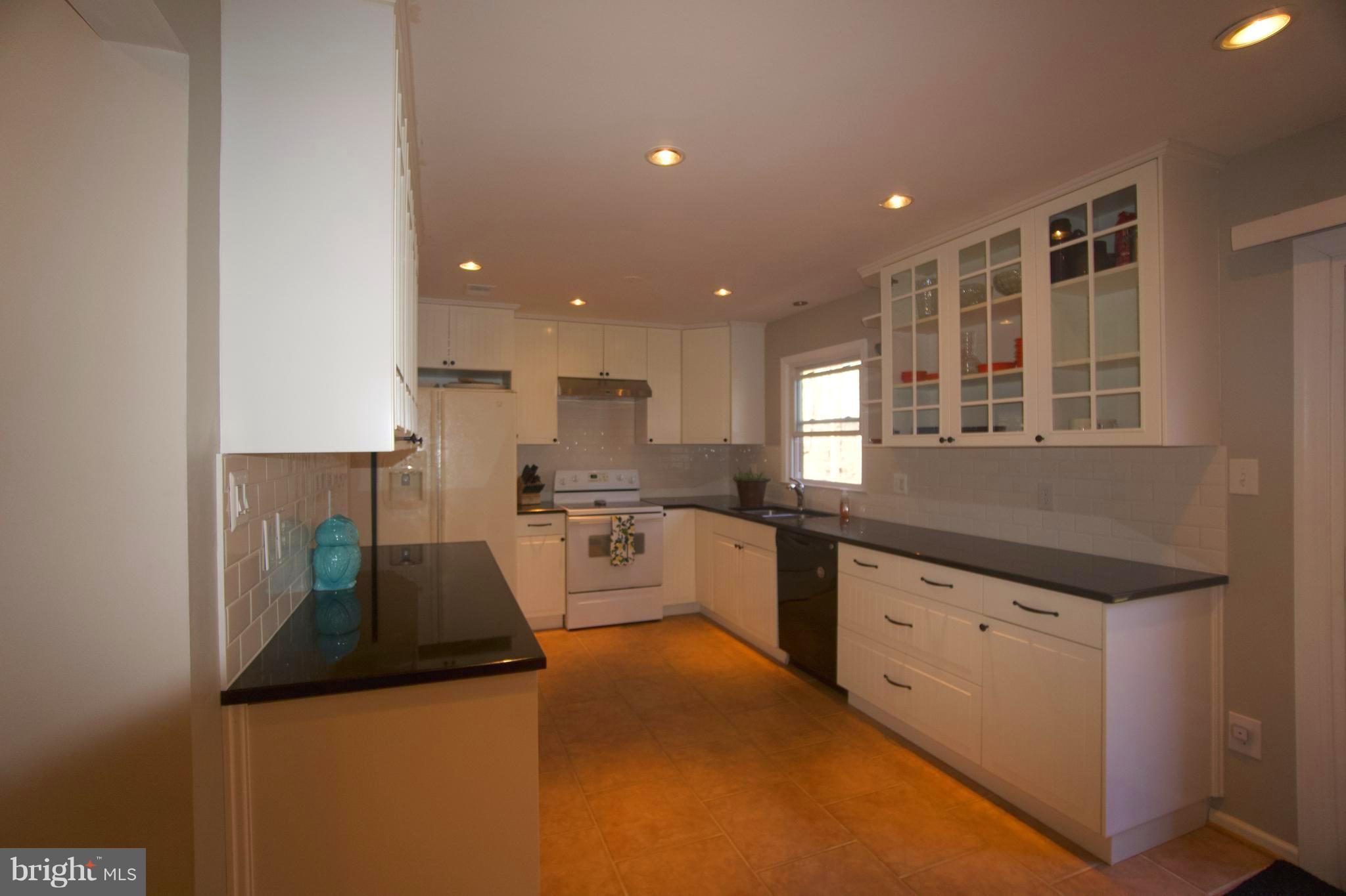 6261 Rathlin Drive Springfield, VA 22152 - Photo 8 of 26 a kitchen with granite countertop white cabinets and white appliances