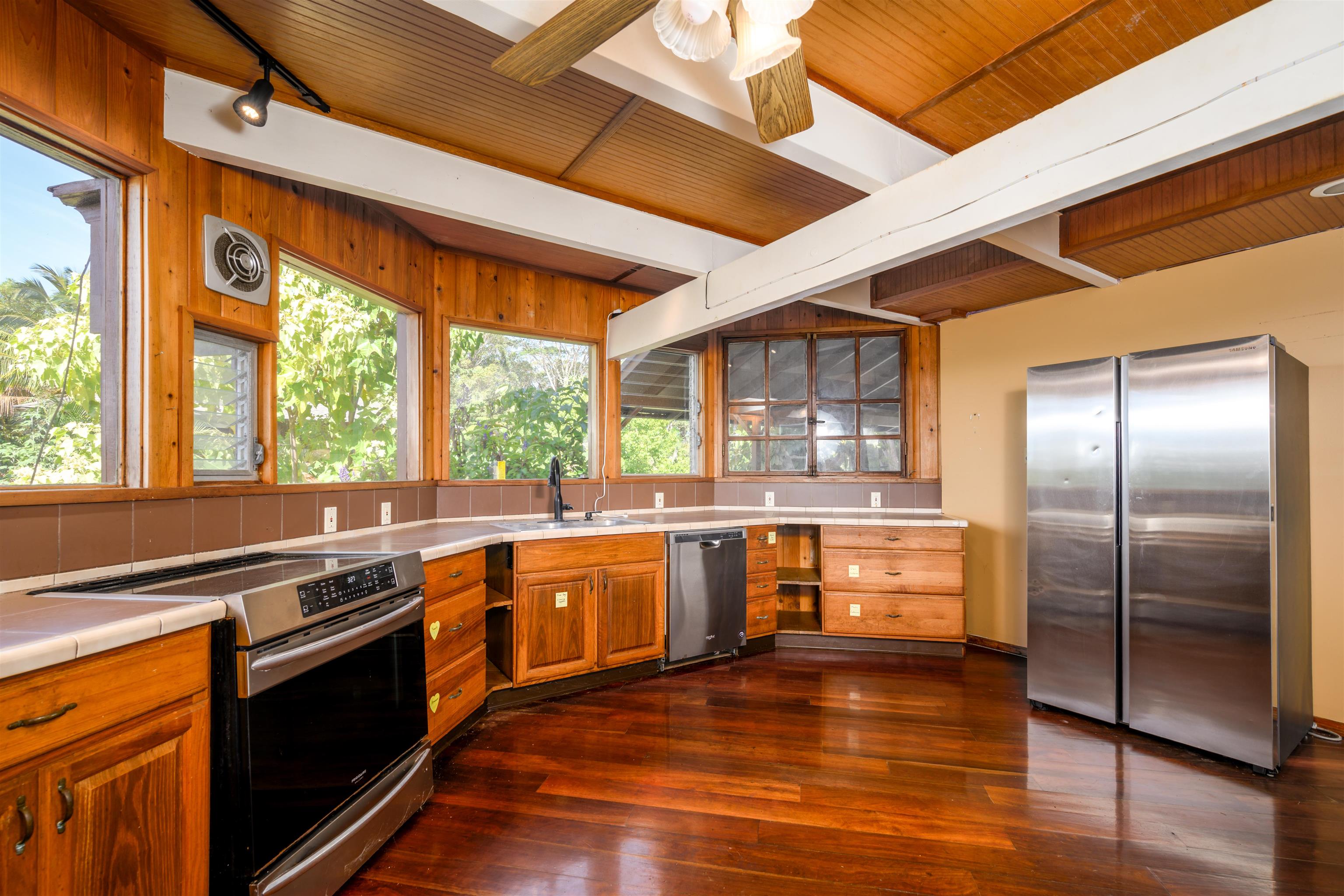 810 Upper Ulumalu Road Haiku, HI 96708 - Photo 11 of 46 a large kitchen with stainless steel appliances granite countertop a stove and a large refrigerator