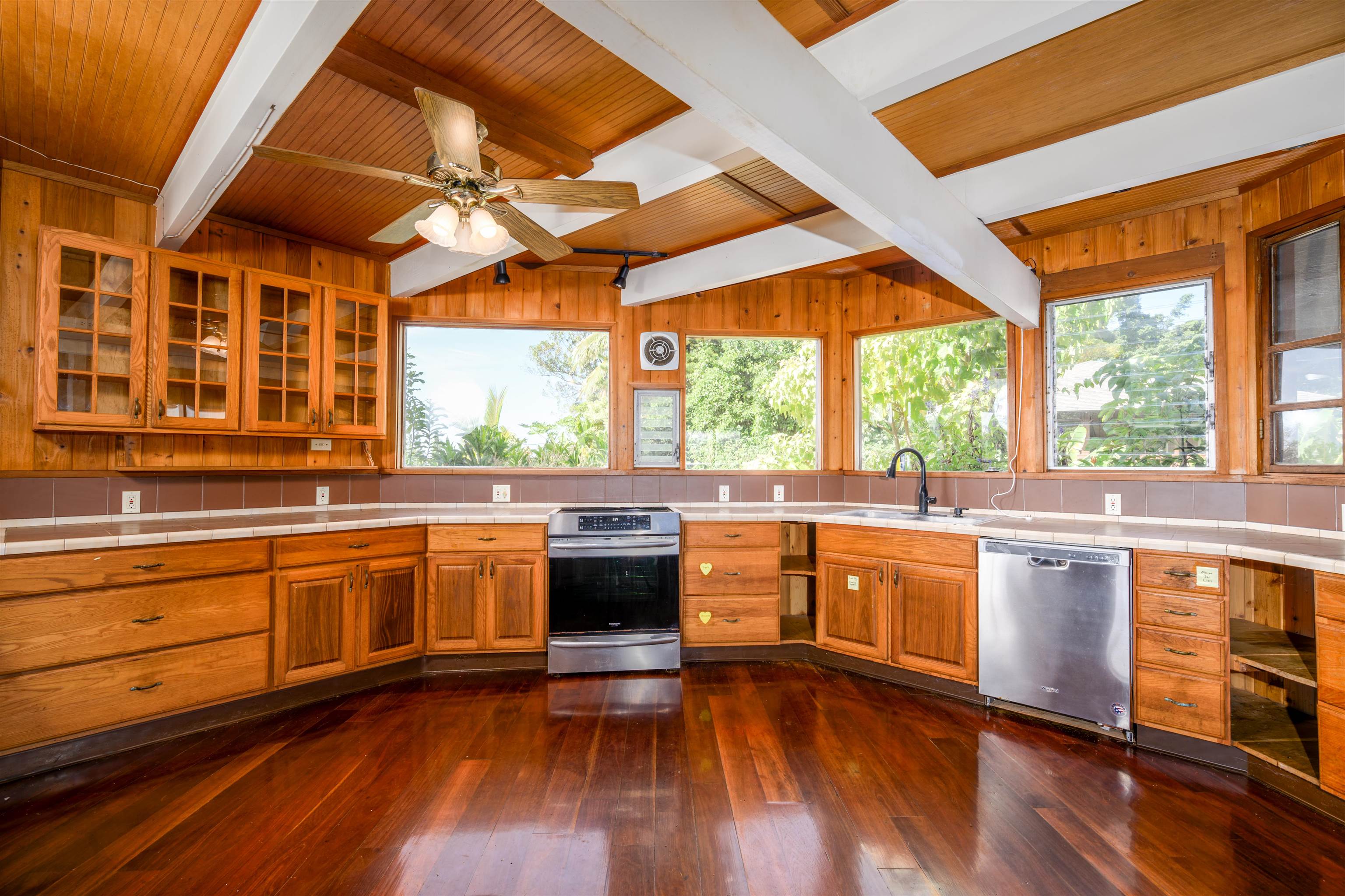 810 Upper Ulumalu Road Haiku, HI 96708 - Photo 12 of 46 a kitchen with stainless steel appliances granite countertop wooden floors and white cabinets