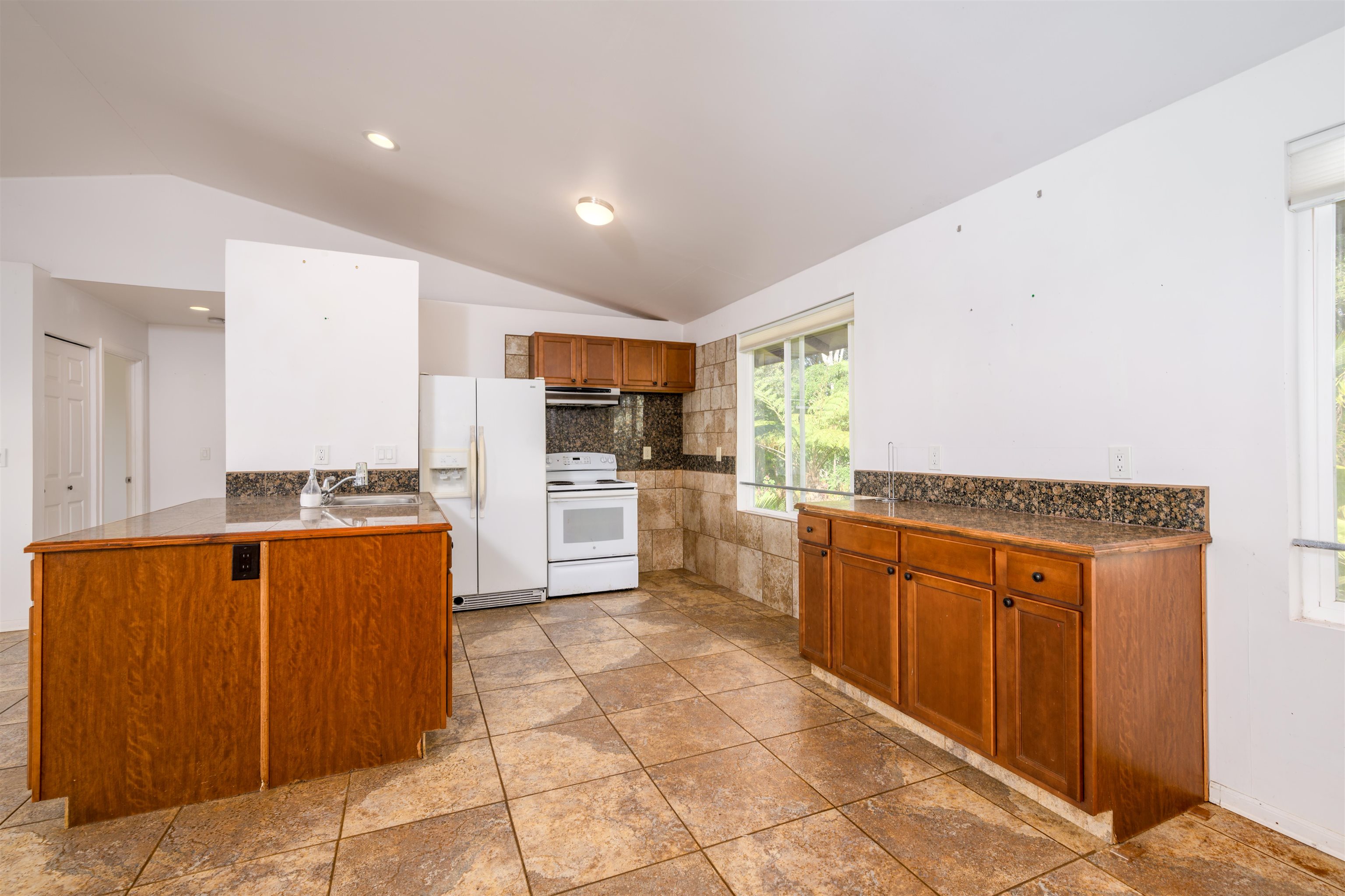 810 Upper Ulumalu Road Haiku, HI 96708 - Photo 37 of 46 a kitchen with stainless steel appliances granite countertop a refrigerator and a stove top oven