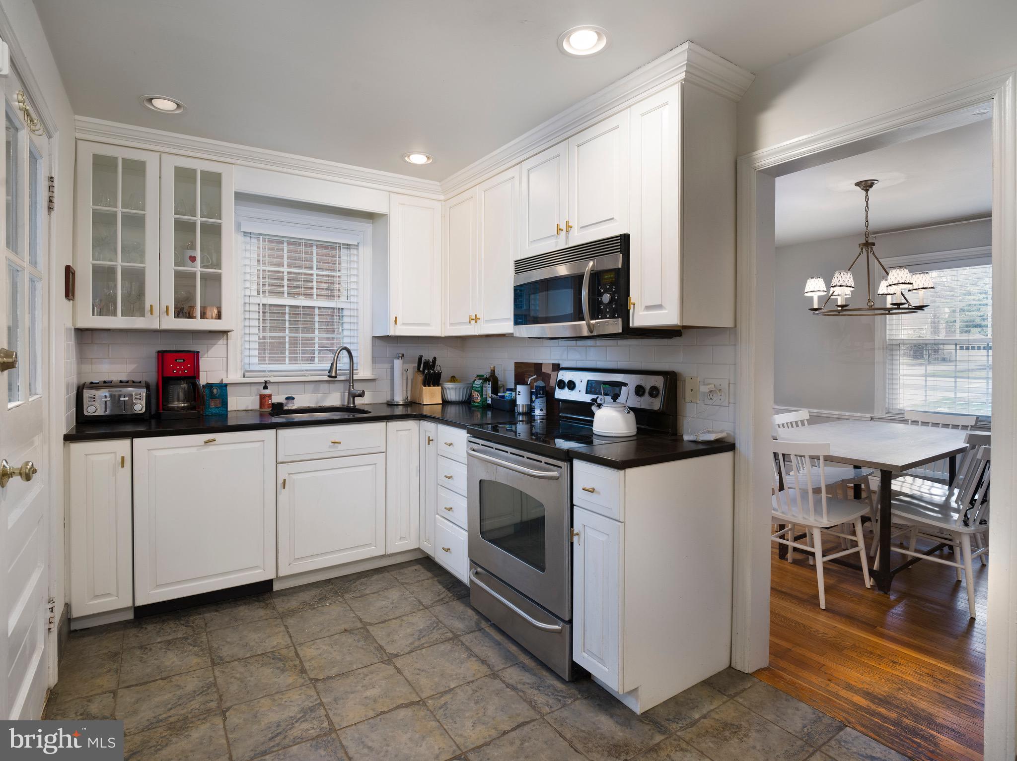 312 Old Lancaster Road Devon, PA 19333 - Photo 7 of 25 a kitchen with stainless steel appliances granite countertop a stove top oven a sink a dining table and chairs