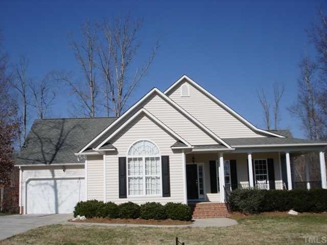 1221 Red Brick Road Garner, NC 27529 - Photo 2 of 11 a view of a white house with large windows and a yard