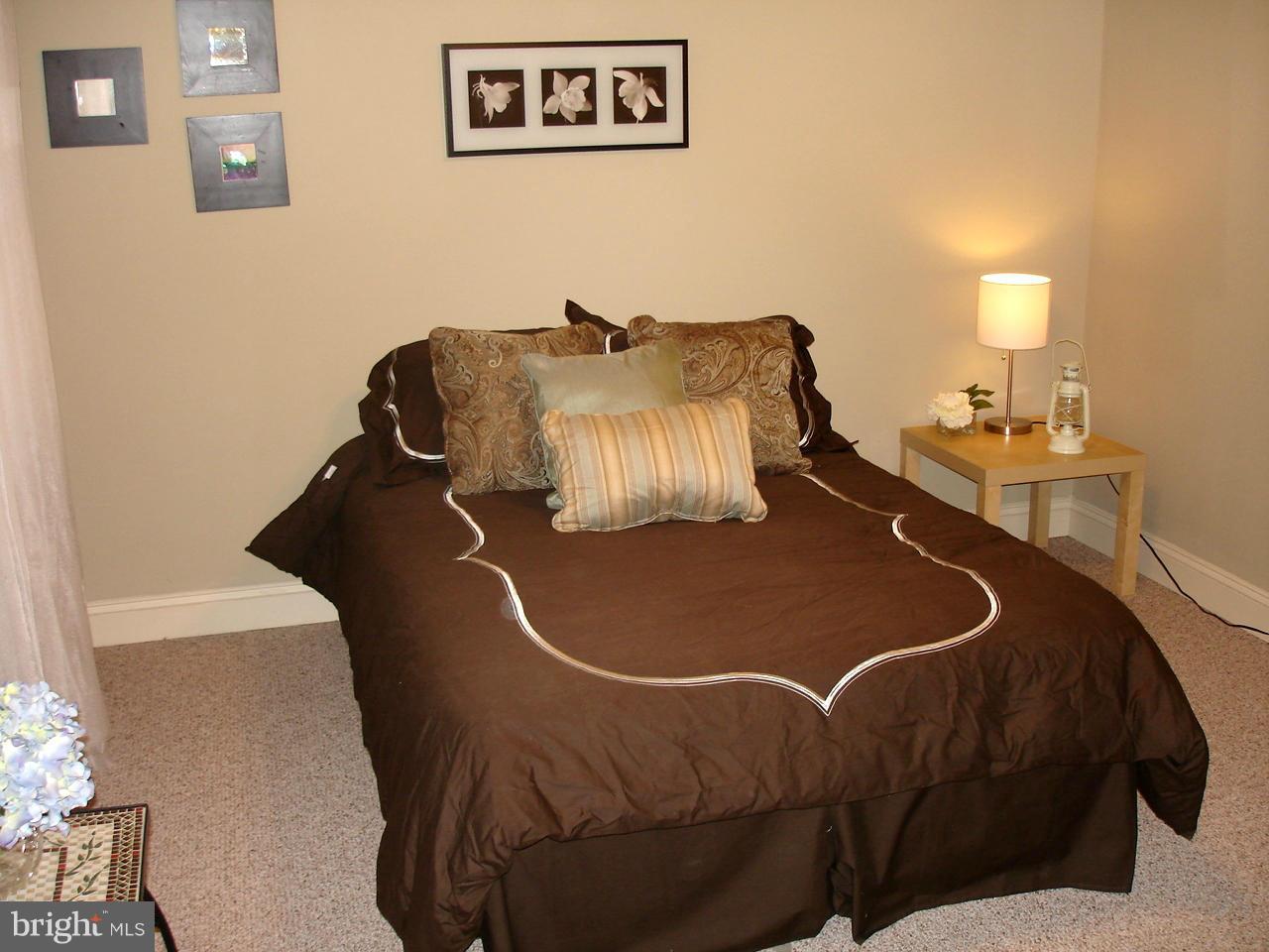 3412 Dunran Road Dundalk, MD 21222 - Photo 12 of 25 a bed sitting in a bedroom next to a lamp