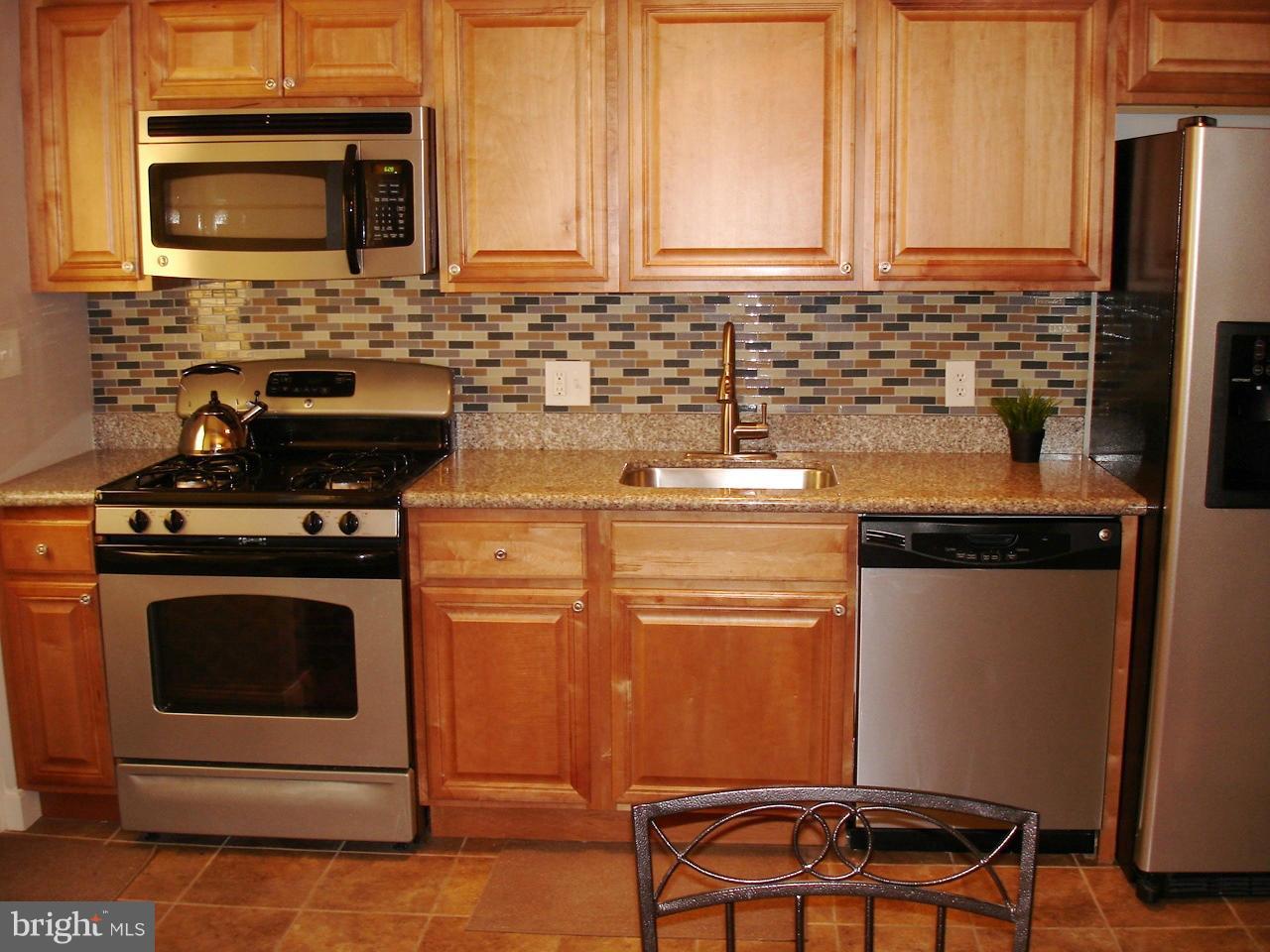 3412 Dunran Road Dundalk, MD 21222 - Photo 6 of 25 a kitchen with stainless steel appliances wooden cabinets and a stove top oven