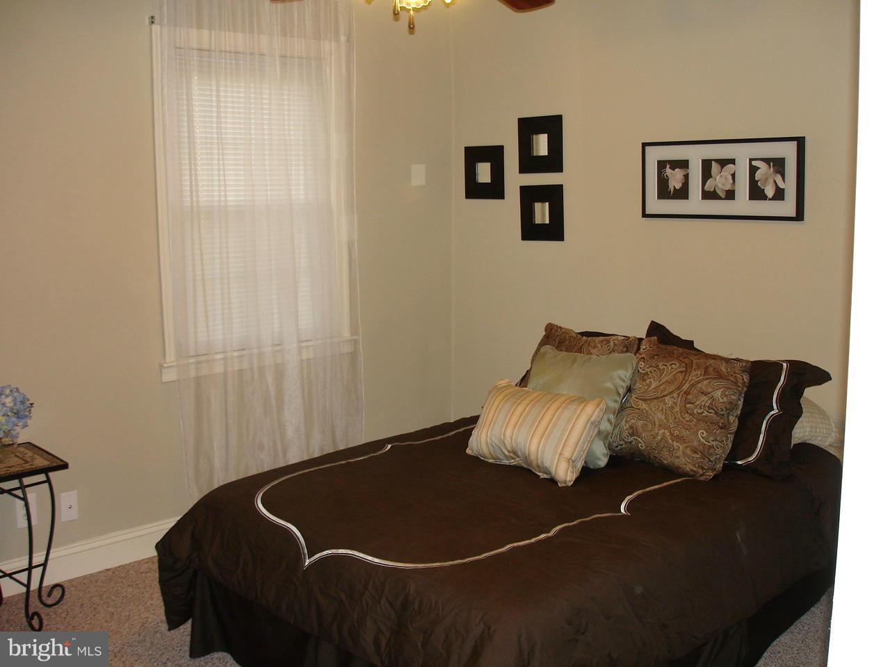 3412 Dunran Road Dundalk, MD 21222 - Photo 8 of 25 a bed sitting in a bedroom next to a window and a lamp