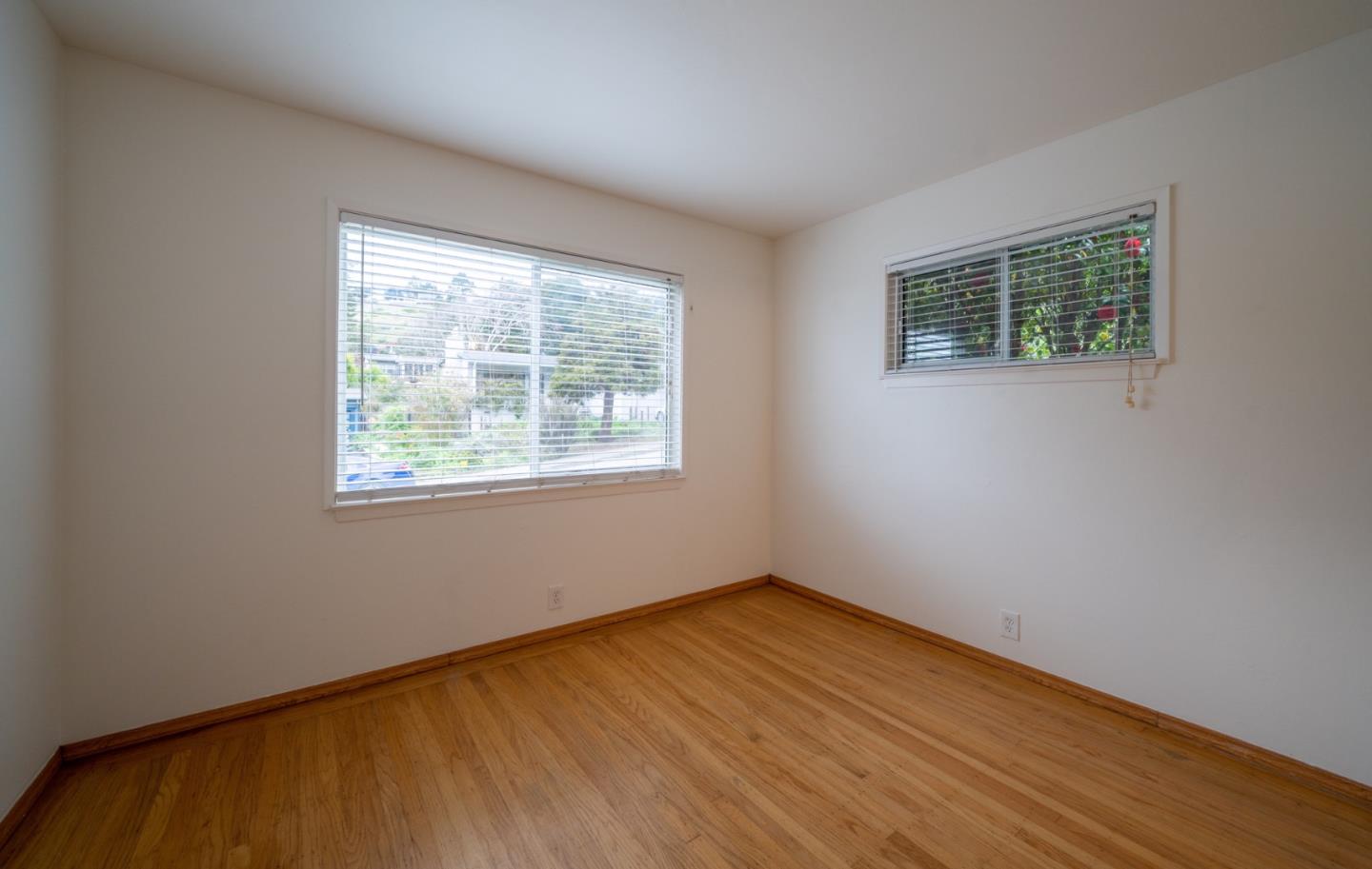616 Brighton Road Pacifica, CA 94044 - Photo 14 of 14 a view of an empty room with wooden floor and a window
