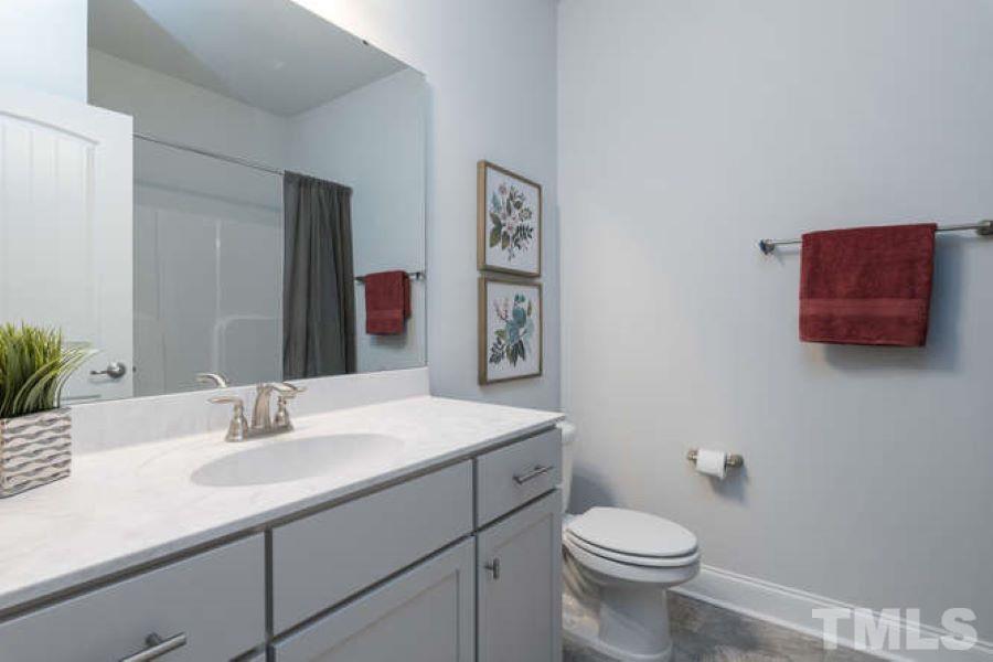 a bathroom with a sink vanity mirror and toilet