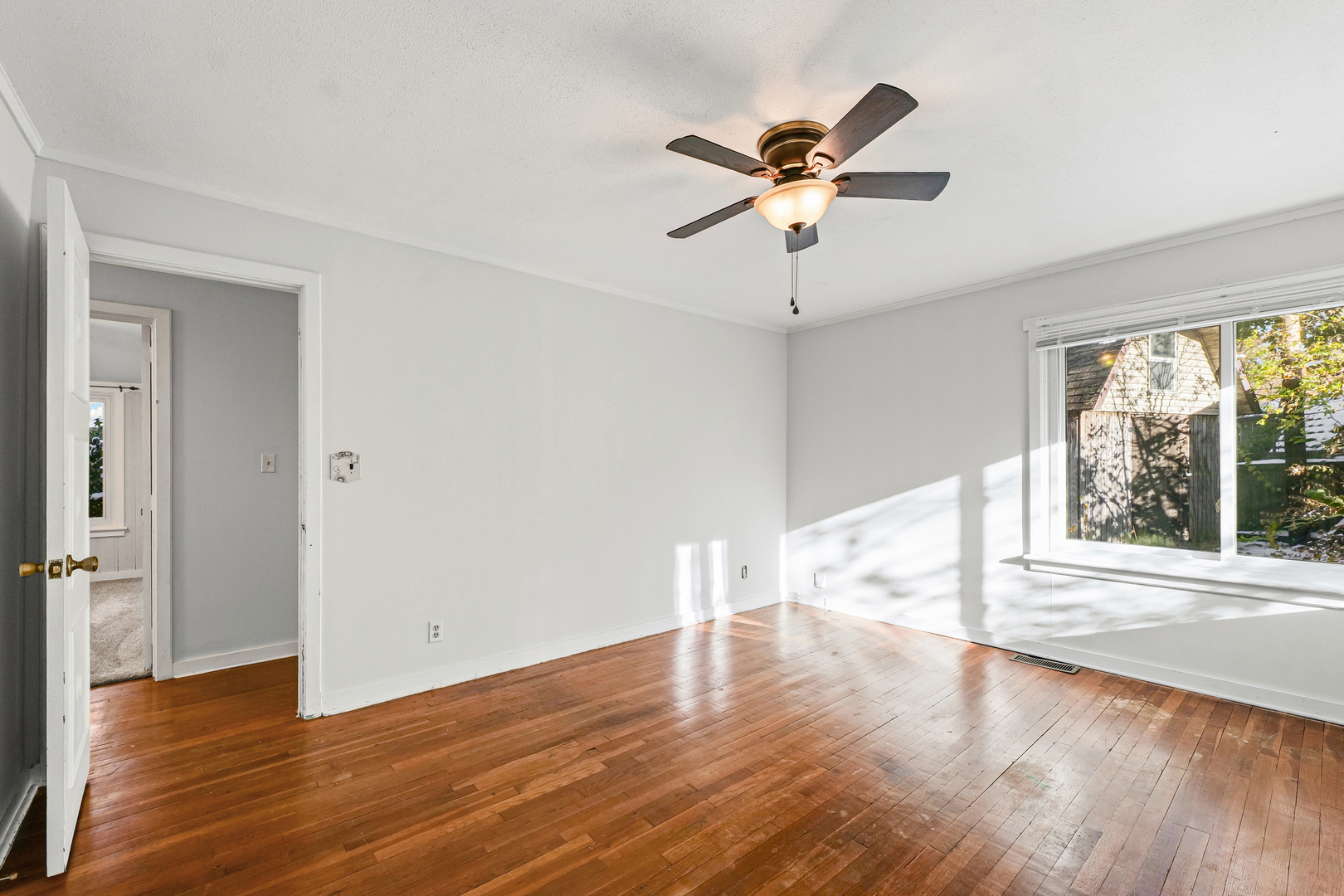 302 Flora Drive Champaign, IL 61821 - Photo 25 of 34 an empty room with wooden floor fan and windows