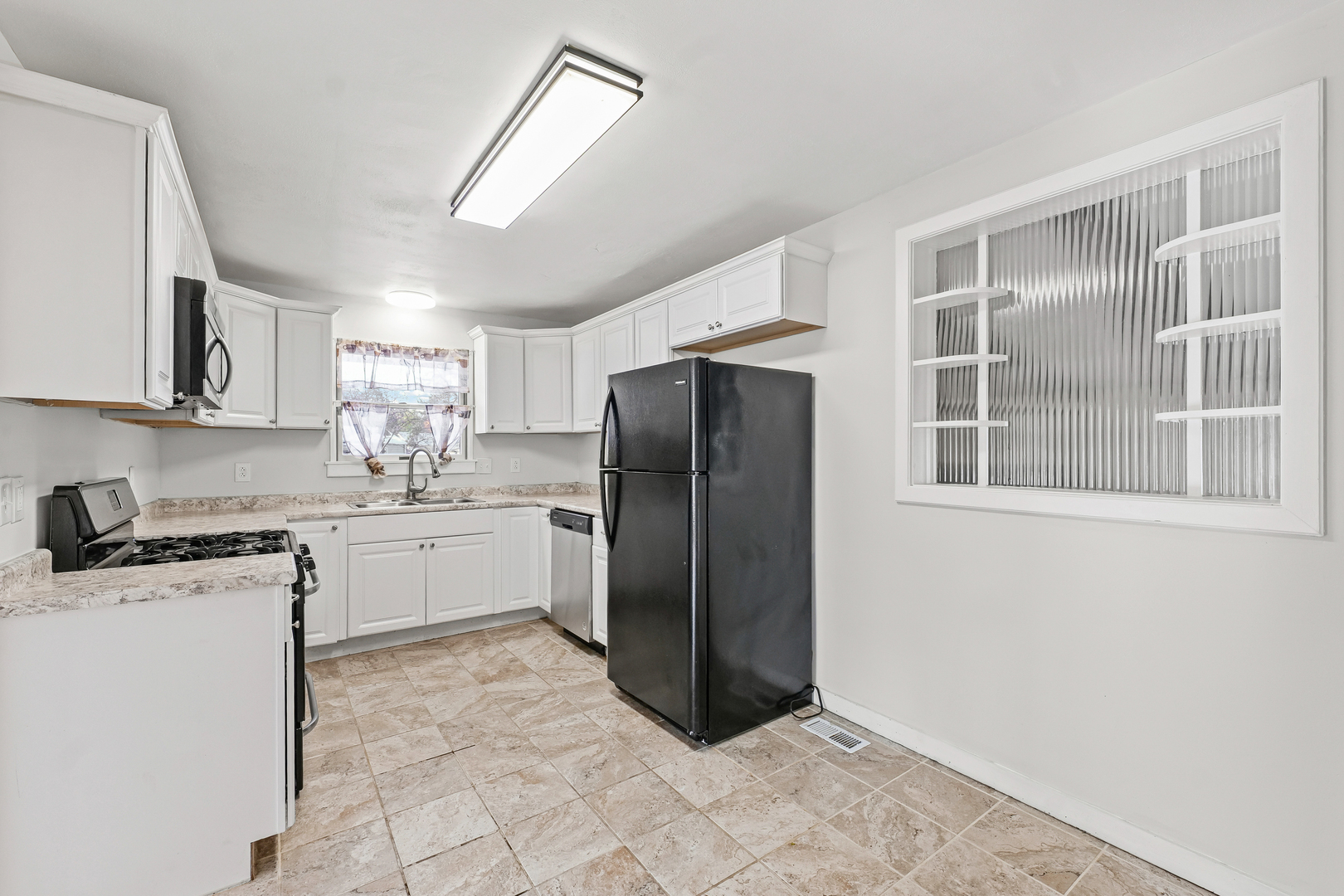 302 Flora Drive Champaign, IL 61821 - Photo 9 of 34 a kitchen with stainless steel appliances granite countertop a refrigerator sink and cabinets