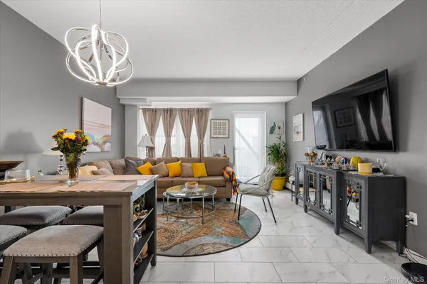 a living room with furniture a chandelier and a dining table