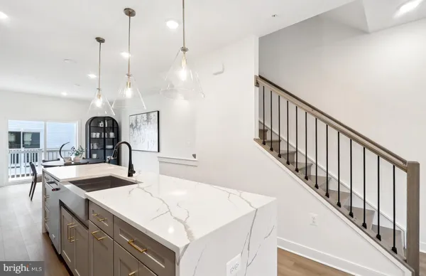 a kitchen with kitchen island a sink and a stove with wooden floor
