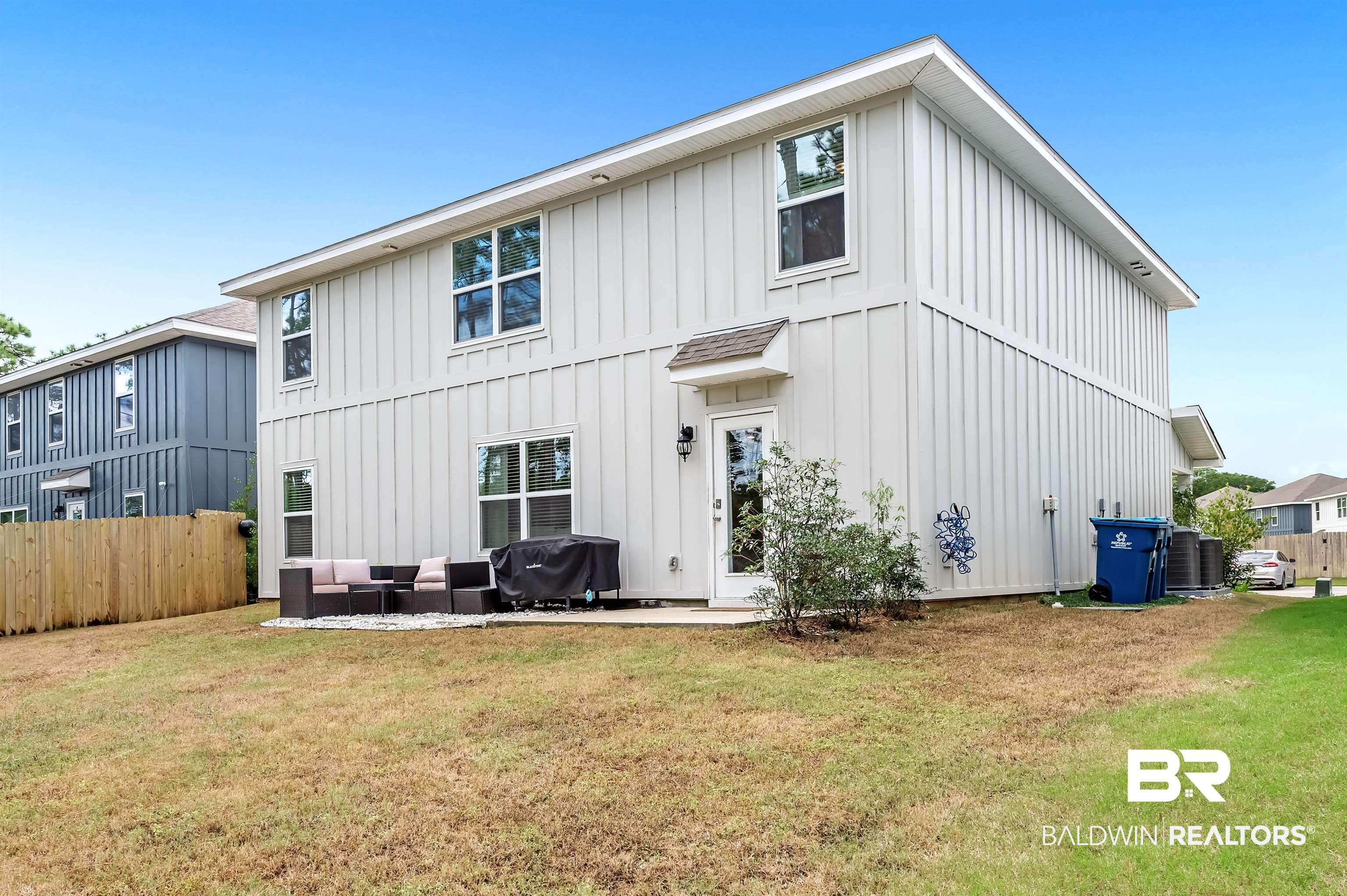 24549 Broken Sound Loop Orange Beach, AL 36561 - Photo 5 of 57 Rear view of property with outdoor lounge area, a patio area, central AC, and a yard