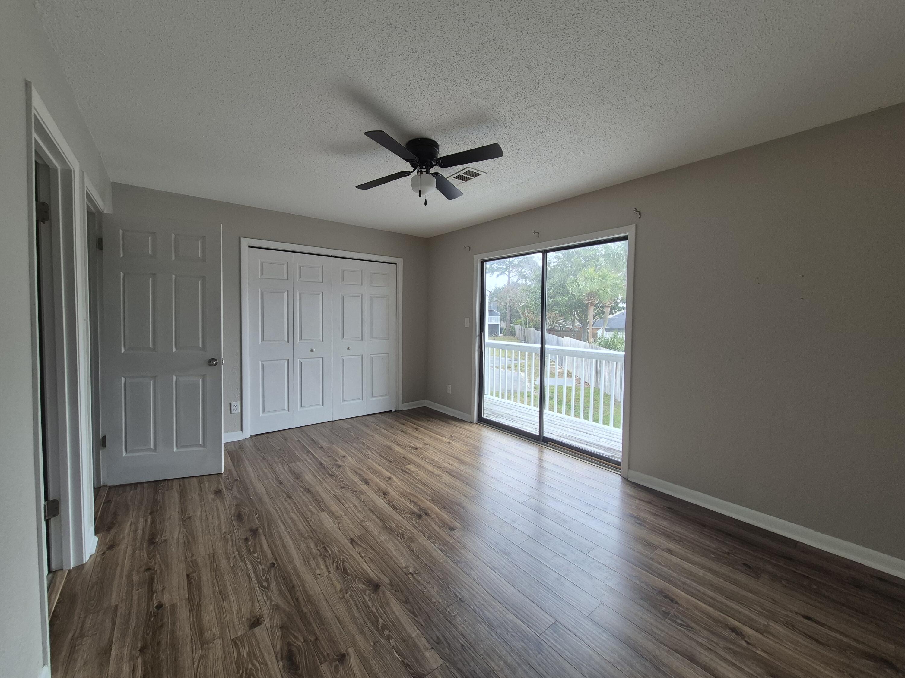 26 Court Destin, Unit 26 Destin, FL 32541 - Photo 11 of 14 a view of empty room with wooden floor and fan