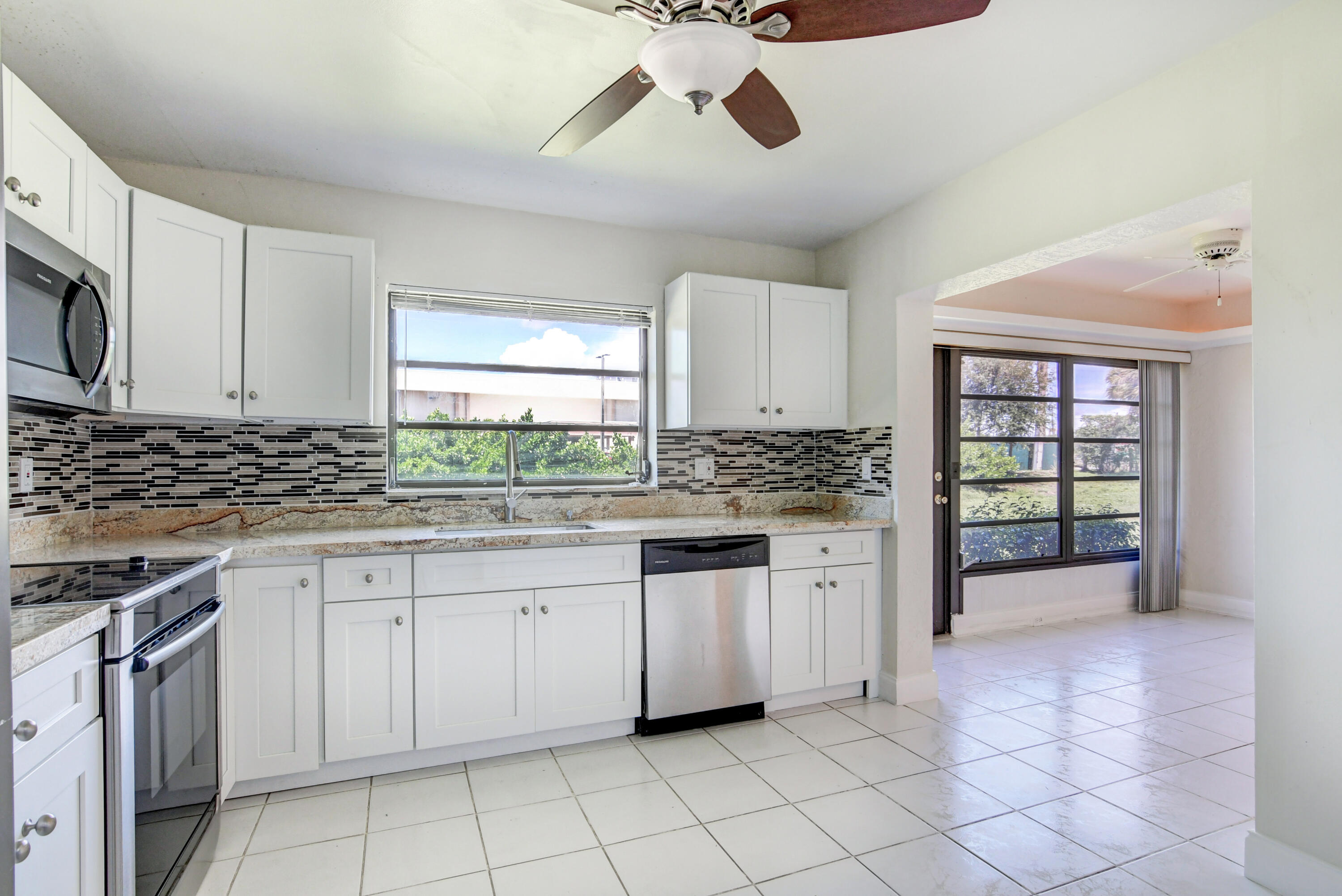 4867 Hawkwood Road, Unit B Boynton Beach, FL 33436 - Photo 13 of 37 a kitchen with white cabinets and appliances
