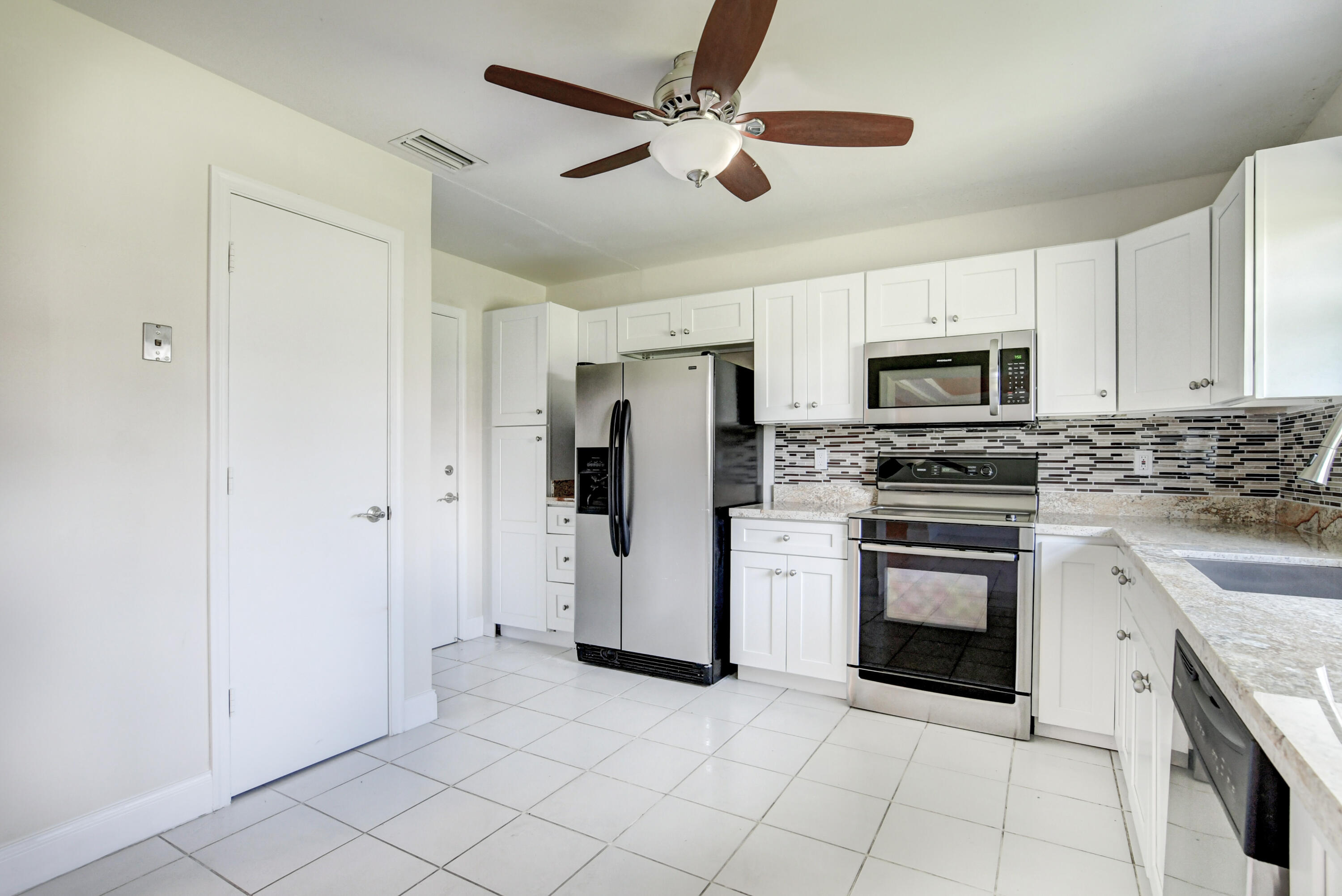 4867 Hawkwood Road, Unit B Boynton Beach, FL 33436 - Photo 14 of 37 a kitchen with cabinets stainless steel appliances and a counter space