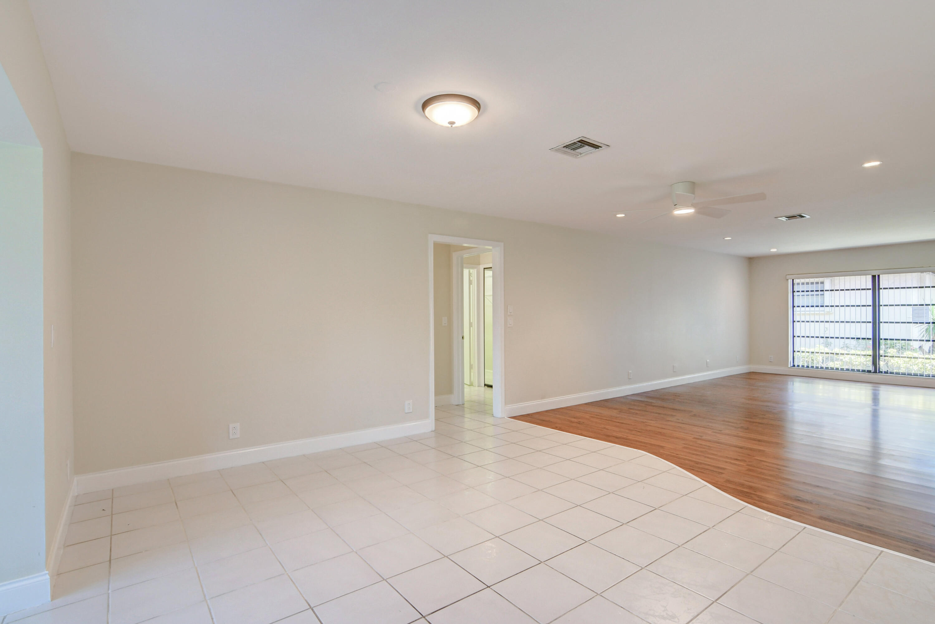 4867 Hawkwood Road, Unit B Boynton Beach, FL 33436 - Photo 16 of 37 an empty room with wooden floor and windows